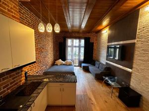 a kitchen and living room with a brick wall at Magic Sopot Apartments in Sopot