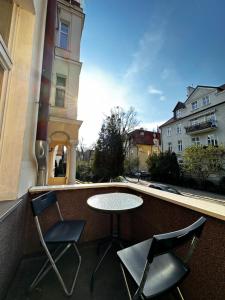 a table and two chairs on a balcony with a view at Magic Sopot Apartments in Sopot