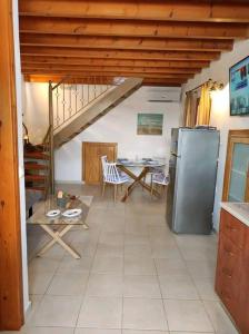 a kitchen with a refrigerator and a table with chairs at Nikόla's House in Mourniaí