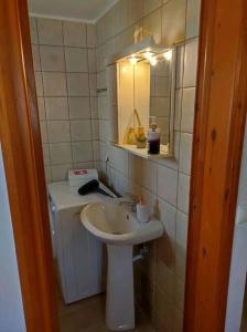 a small bathroom with a sink and a mirror at Nikόla's House in Mourniaí
