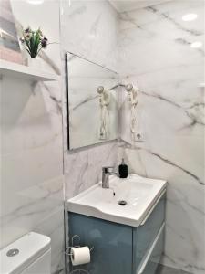 Un baño blanco con lavabo y espejo. en Porto Ville Touring, en Oporto