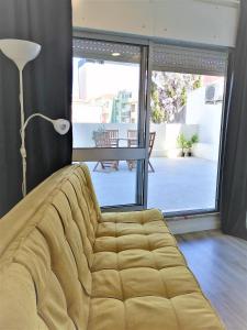 a couch in a living room with a large window at Porto Ville Touring in Porto