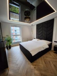 ein großes Schlafzimmer mit einem großen Bett und einem Kronleuchter in der Unterkunft Marina Apartments in Danzig
