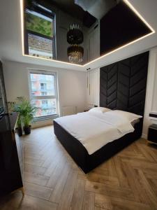 een grote slaapkamer met een groot bed en een kroonluchter bij Marina Apartments in Gdańsk +17 foto's