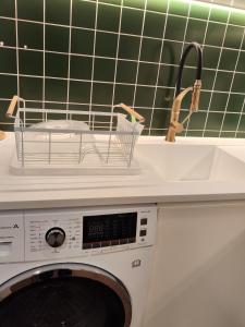 a washing machine in a kitchen with a sink at Casa Moliceiro Verde in Aveiro