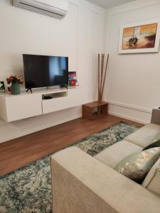 a living room with a couch and a flat screen tv at Casa Moliceiro Verde in Aveiro