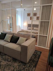 sala de estar con sofá y cama en Casa Moliceiro Verde, en Aveiro