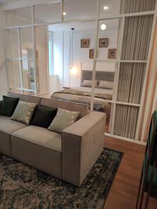 a living room with a couch and a bed at Casa Moliceiro Verde in Aveiro
