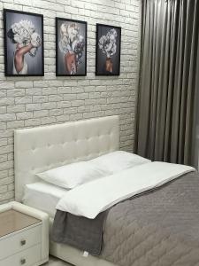 彼得巴甫洛夫斯克的住宿－Дизайнерская квартира в центре города，卧室配有一张四幅画的墙壁床。