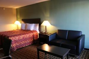 a hotel room with a bed and a chair at Kings Inn Civic Center/UAB in Birmingham