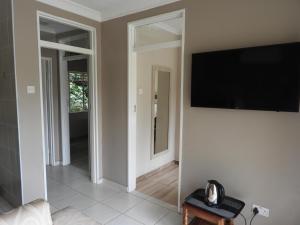 uma sala de estar com uma televisão de ecrã plano na parede em 2 Bed Apt with en-suite and kitchenette - 2067 em Harare