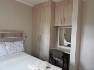 um quarto com uma cama, um lavatório e um espelho em 2 Bed Apt with en-suite and kitchenette - 2067 em Harare