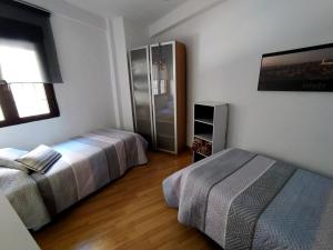 トレドにあるApartamento Centro de Toledoのベッドルーム1室(ベッド2台、冷蔵庫付)