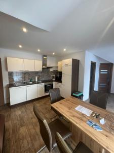 una cucina e una sala da pranzo con tavolo e sedie in legno di Terezia-Appartements Nassfeld a Hermagor