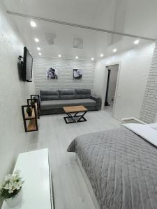 un soggiorno con letto e divano di Дизайнерская квартира в центре города a Petropavlovsk