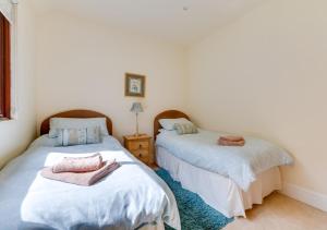 a bedroom with two beds with towels on them at Sugarloaf Cottage in Brightling