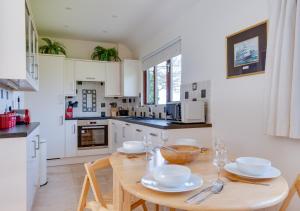 a kitchen with a wooden table with dishes on it at Sugarloaf Cottage in Brightling