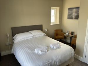 a bedroom with a bed with two towels on it at The Duke of Cornwall in St Austell