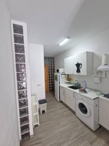 Una cocina con lavadora y secadora en una habitación. en Apartamento jable, en Arrecife
