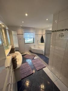 a bathroom with a tub and a toilet and a sink at Terezia-Appartements Nassfeld in Hermagor