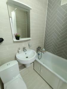 biała łazienka z umywalką i toaletą w obiekcie Дизайнерская квартира в центре города w mieście Pietropawłowsk Kamczacki