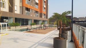 a courtyard with a palm tree in a building at Apartamento Wi-fi, Split, Estacionamento e Piscina in Ribeirão Preto