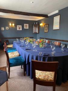 una sala da pranzo con un lungo tavolo blu con fiori di The Chequers Inn a Froggatt