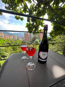 a bottle of wine and two glasses on a table at Loft bambu in Envigado
