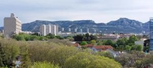 una ciudad con edificios y montañas en el fondo en Sea Sun & Beaches, Prado Vélodrome, en Marsella