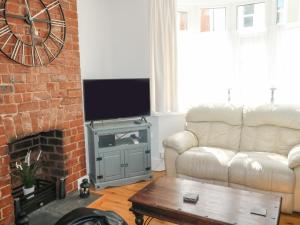 a living room with a couch and a fireplace at Driftwood in Exmouth