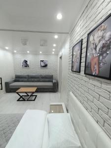 - un salon avec un canapé et un mur en briques dans l'établissement Дизайнерская квартира в центре города, à Petropavlovsk-Kamtchatski