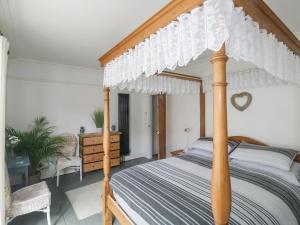 a bedroom with a bed with a wooden canopy at Driftwood in Exmouth