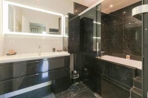 a bathroom with a shower and a sink and a tub at Golf House Disneyland BMYGUEST in Bussy-Saint-Georges