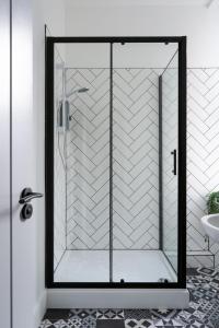 een douche met een glazen deur in de badkamer bij Torquay Heights Modern Apartments in Torquay