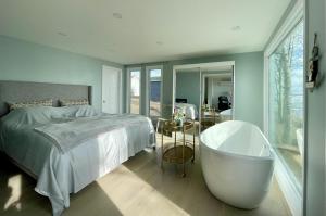 a bedroom with a large bed and a bath tub at Lucky Bay Hideaway - Seafront at Notre Dame 