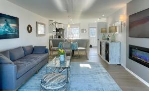 ein Wohnzimmer mit einem blauen Sofa und einem Tisch in der Unterkunft Lucky Bay Hideaway - Seafront at Notre Dame 