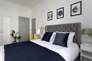 a bedroom with a large bed with blue pillows at Torquay Heights Modern Apartments in Torquay