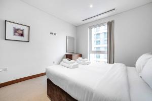 a white bedroom with a large bed and a window at 2 BR 2BTH apt near Battersea Power Station in London