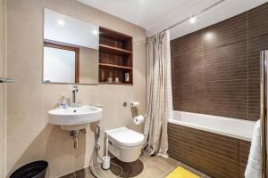 a bathroom with a sink and a toilet and a tub at 2 BR 2BTH apt near Battersea Power Station in London