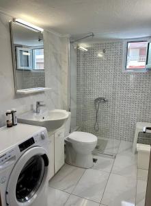 łazienka z pralką, toaletą i umywalką w obiekcie Uranias Beach House w mieście Kalivia Poligirou