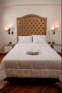 a bedroom with a large bed with a large headboard at MELTHON URBANS in Ayacucho