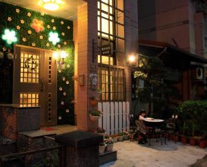 a person sitting at a table outside of a building at night at Gloria House in Hualien City