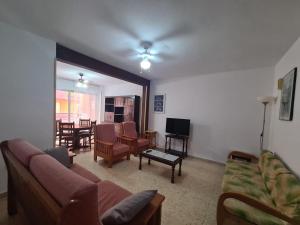 salon z kanapą, krzesłami i stołem w obiekcie Apartamento El Cid IF Benidorm w mieście Benidorm