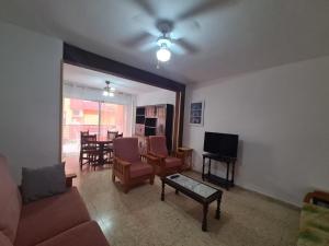 un soggiorno con divano, TV e tavolo di Apartamento Edificio El Cid a Benidorm