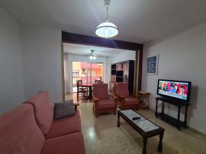 un soggiorno con divano e TV di Apartamento Edificio El Cid a Benidorm