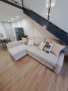 un sofá blanco en una sala de estar con suelo de madera en Privitera Home, en Catania