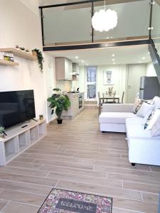 Una sala de estar con un sofá blanco y un televisor. en Privitera Home, en Catania