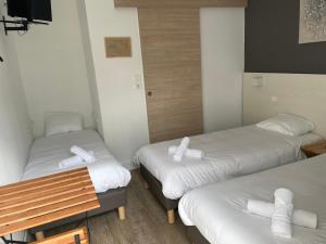 una camera d'albergo con due letti e un tavolo di Europe Hotel a Beaurepaire-en-Bresse