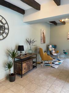 a living room with furniture and a clock on the wall at Cottage - The Moulin Treillard - Sleeps3 - Parking in Saint-Hilaire-La-Treille