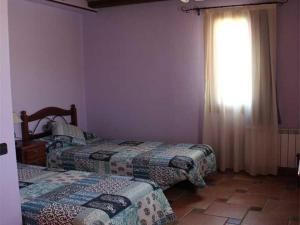 a bedroom with two beds and a window with curtains at HOSTAL LA SAVINA in Cervera